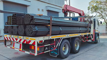 Trucks with long trailers carry rebar for building construction. Construction steel ready to be...