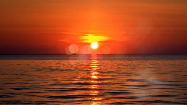 Sunset in the sea paints the horizon with a palette of warm hues, casting a mesmerizing glow across the water.