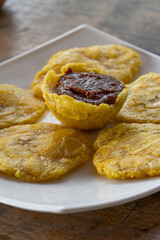 Sumérgete en la cocina caribeña con esta mezcla perfecta de patacones crujientes y frijoles especiados, una experiencia gastronómica única.