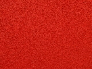 A bright red wall standing out against a plain white background, creating a stark contrast