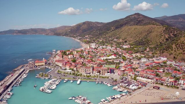 4k drone flight back footage (Ultra High Definition) of Acciaroli port with luxury yachts. Bright summer scene of Mediterraneanm coast of Italy. Traveling concept background.