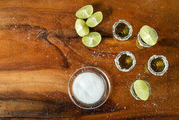 Shots of tequila with salt and lemon on a wooden table. Festive background cinco de mayo and mexican independence day.