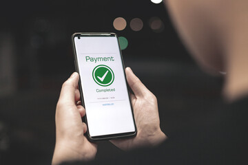 Payment complete Notifications. Customer using online banking application on smartphone to pay for purchases online and product in department store