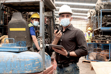 Industrial foreman worker wearing a mask to prevent dust in workplace while inspecting at...