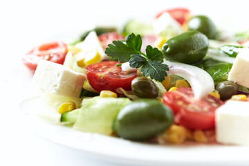 Healthy Salad with Feta Cheese, Green Olives, Baby Spinach, Cucumber, Cherry Tomatoes and Capers. Bright background. Close up.	