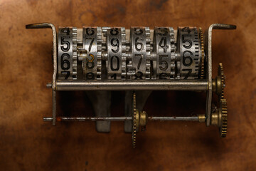 Abstract epoch counter. Old counter mechanism on a bronze sheet.