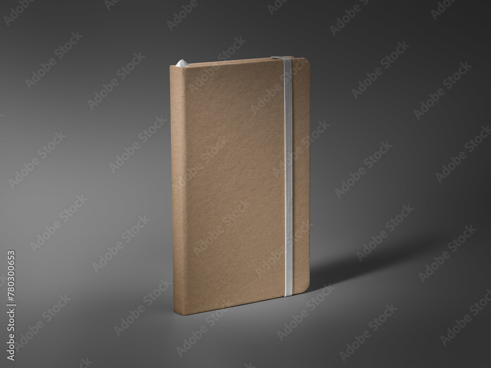 Poster mockup of a closed craft notebook, standing on a darkened background, with a white elastic band, a b