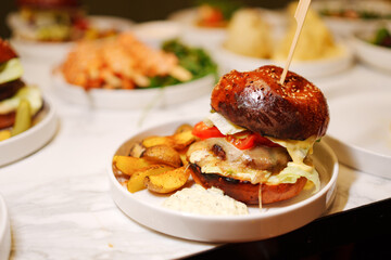 A classic American dish of a hamburger and french fries served on a plate with tableware, a staple...