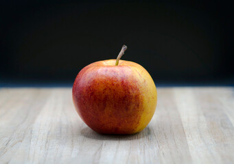 Gala apple on wooden board with black background