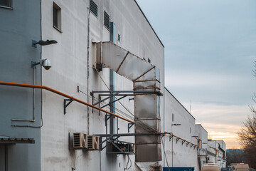 Industrial warehouse building with air conditioner equipment, security cameras and van vehicles