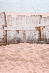 Wooden plank fencing on Danube river sandy beach, vertical image