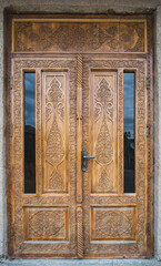 An ancient wooden door with patterns and ornaments in the ancient city of Khiva in Uzbekistan, wood carving