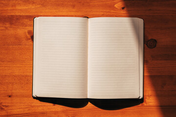 Top view of open notebook with blank pages with lines, mockup copy space journal on the desk