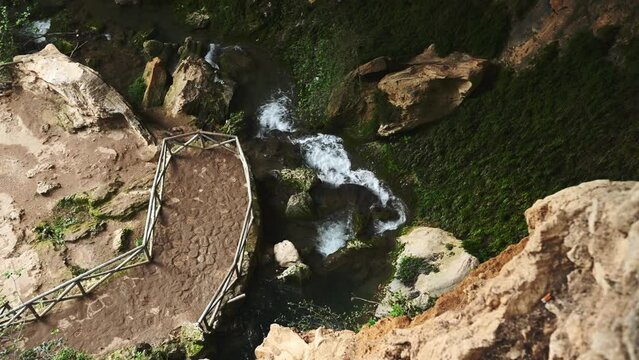 Crystal clear water in small mountain river. Fast stream in a cave overgrown with wild ivy with small waterfalls. Directly above. Waterfall in mountains. La Sierra de Cazorla. Steadicam shot