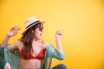 Young Latina Woman Dancing with Excitement on Yellow Background - obrazy, fototapety, plakaty