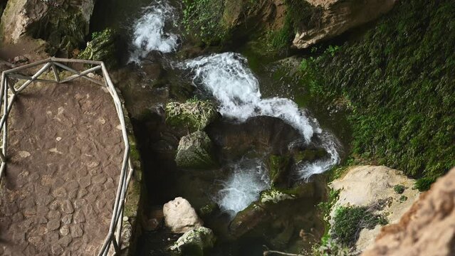 Crystal clear water in small mountain river. Fast stream in a cave overgrown with wild ivy with small waterfalls. Directly above. Waterfall in mountains. La Sierra de Cazorla