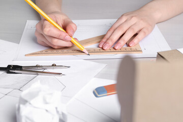Woman creating packaging design at light wooden table, closeup