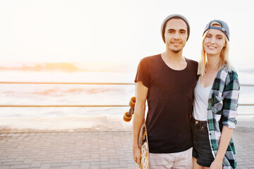 Couple, skateboard and happy on beach for fun with mockup space, adventure and promenade date. Gen...