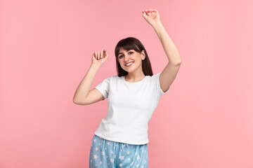 Happy woman in pyjama on pink background