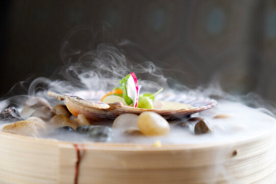 Upscale restaurant dish with clam shell on dry ice