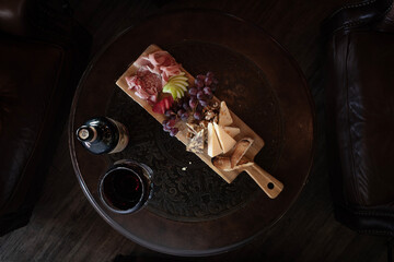 Overhead view of a pub board on round table with bottle of wine