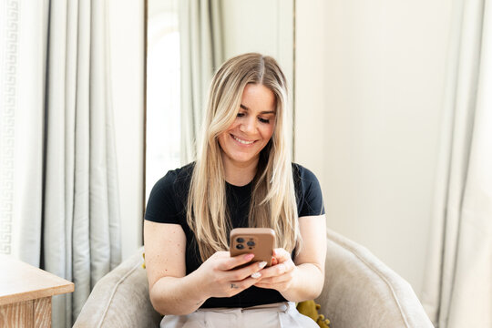 Smiling woman texting on smartphone