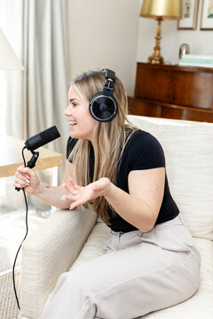 nimated woman recording, speaking into podcast microphone