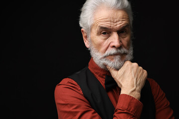 Senior man with mustache on black background, space for text