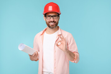 Architect in hard hat with draft showing OK gesture on light blue background