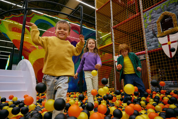 Cheerful little children spending time at daycare indoor playground