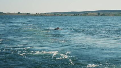 A trail of water on a lake seen behind a speeding motorboat on a clear day, the surface of the water