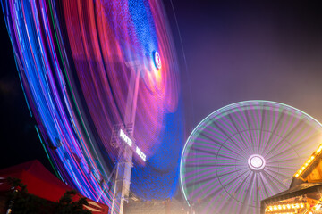 Carnival lights at night - The fun of summertime carnival and fair rides at night with colorful...