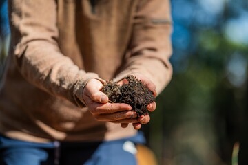 farmer hold soil in hands monitoring soil health on a farm. conducting soil tests