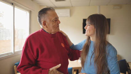 granddaughter and grandfather talking happily in a retirement home