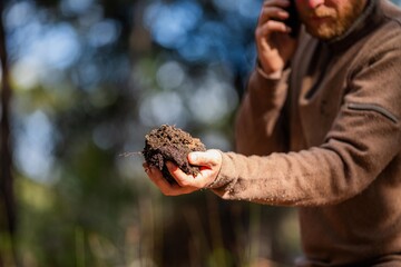 regenerative organic farmer, taking soil samples and looking at plant growth in a farm. practicing sustainable agriculture in australia