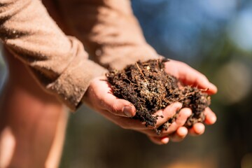 agronomist on a farm practicing agronomy holding soil, doing soil tests in her home laboratory. Looking at soil life and health