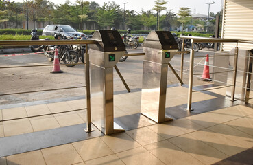 A closeup picture of a turnstile gate near a corporate campus