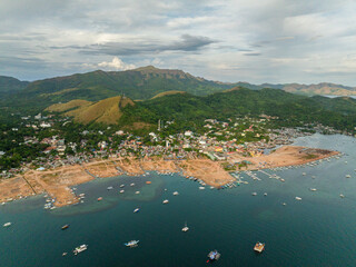 Pier with tour boats in Coron Town Proper. Mountain hills, view from drone. Palawan, Philippines.