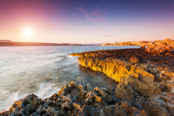 A picturesque view of the volcanic coast at sunrise. Qawra, Malta, Europe.