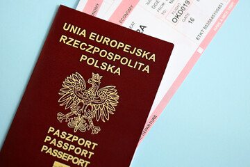 Poland passport with airline tickets on blue background close up. Tourism and travel concept