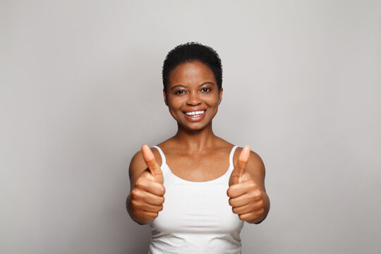 Attractive smiling woman showing thumb up on white background