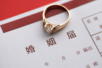 Japanese marriage registration blank document and wedding proposition ring on table close up