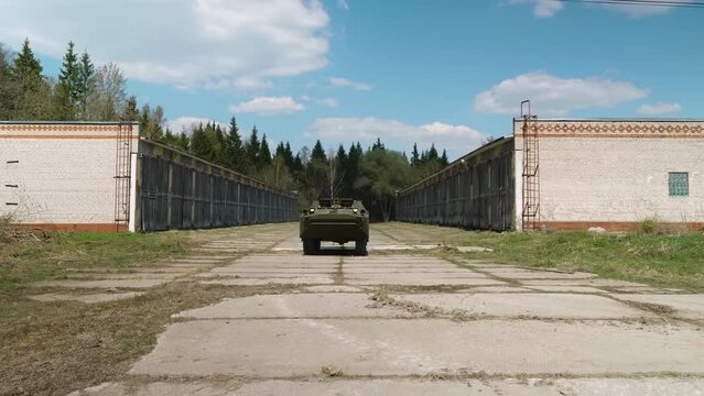 A green, mid-20th century Soviet armored reconnaissance and patrol vehicle in motion, kicking up dust, designed for military reconnaissance.