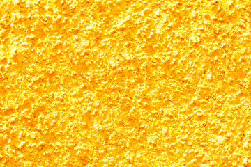 Gold yellow texture of a concrete wall. Closeup of yellow painted background of a concrete wall...