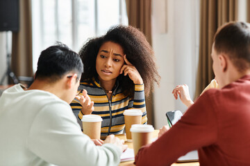 A diverse group of students engaged in a lively conversation around a table in an educational...