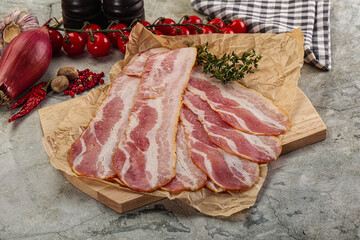 Sliced pork bacon over board