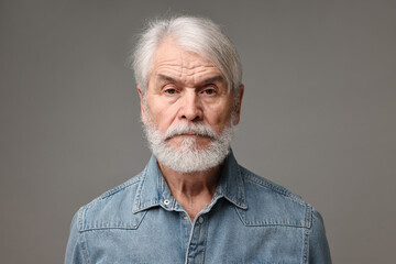 Senior man with mustache on grey background