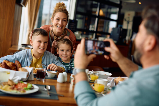 Happy family having fun while taking picture during their breakfast in  restaurant.