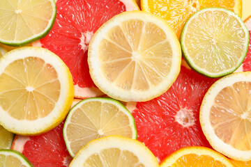 Different sliced citrus fruits as background, top view