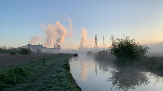 Industry and canal in winter morning with smoke coming from chimney England UK 4K